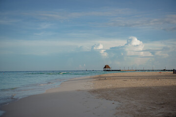 Obraz premium Caribbean Sea beach with azure water and thatched hut on the horizon.