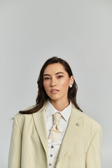 Young woman showcases her beauty and style with a contemporary outfit against a simple backdrop.