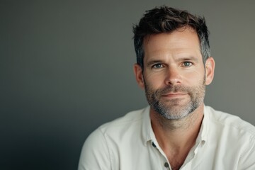 Fototapeta premium Confident Man with Beard in Casual Attire Against a Neutral Background