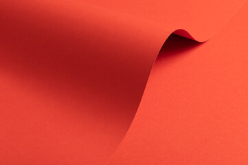 Fiesta red and orange paper background with a matte finish and smooth, curved folds. Vibrant, bold tones and a polished, refined surface create an elegant, stylish, and contemporary aesthetic with a