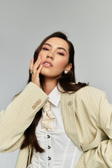 Dressed in a fashionable oversized blazer and top, a woman poses gracefully with poise.