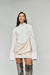 A stylish young woman confidently displays her fashion sense indoors.