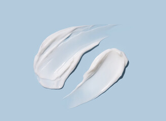 Cosmetic smears of cream texture on pastel blue background. Skin hydration.