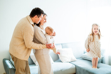 Beautiful happy young family with small children resting at home.