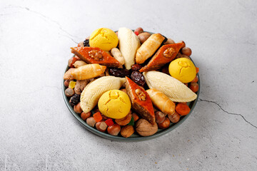 Traditional Azerbaijan holiday Novruz background with green semeni,traditional azerbaijan sweets,shekerbura,qogal,paxlava,mutaki and different nuts and sweets,top view,space for copy