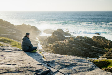 Tourist admiring scenic beauty of Malin Head, Ireland's northernmost point, Wild Atlantic Way, spectacular coastal route. Numerous Discovery Points. Co. Donegal