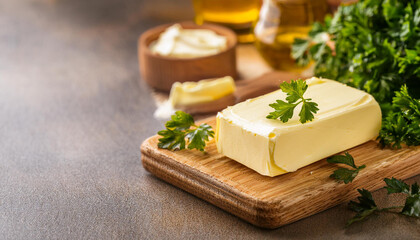 Homemade fresh organic butter with fresh parsley on wooden board. Natural product.