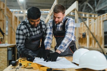 Two architects are looking at a construction plan drawing or blueprint. Construction process