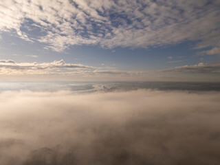 Above the Mist, Below the Clouds: Heavenly Drone Shot with a River in the Distance
