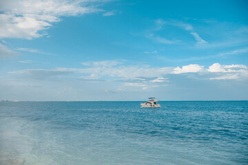 White yacht sails on the Caribbean sea, the sky is cloudy.