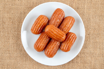 Traditional Turkish dessert tulumba on a plate. Tulumba dessert, fried in oil and soaked in syrup