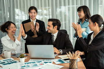Group of happy businesspeople in high five gesture and successful efficient teamwork. Diverse race office worker celebrate after made progress on marketing planning in corporate office. Habiliment