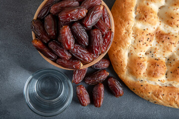 Traditional iftar table with dates fruit,olive and ramadan pita on gray background