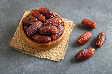 Large size dates fruit in a wooden bowl, top view
