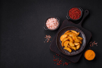 Baked potato wedges with cheese and herbs on a dark background
