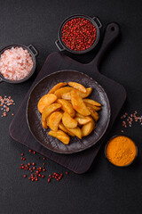 Baked potato wedges with cheese and herbs on a dark background