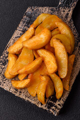 Baked potato wedges with cheese and herbs on a dark background