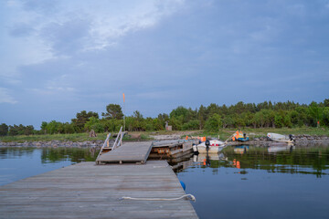 Fototapeta premium Fishing boat pier and boats on the seashore at evening. Fishing boats with net flags by the pier. 