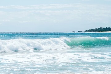 Fototapeta premium pod of dolphins leaping gracefully out of sparkling ocean waves in Byron Bay. 