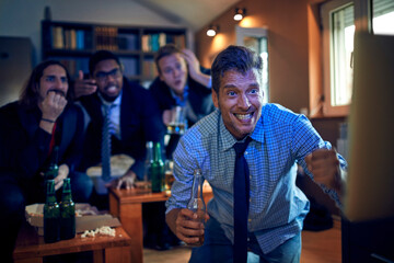 Diverse business colleagues watching sports game with beer at home after work