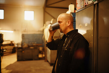 Factory worker taking a coffee break in workshop