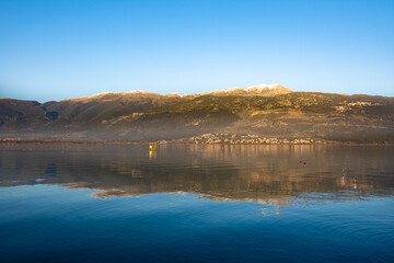 Ioannina Lake in Epirus, Greece: A sunset, with Snow-Capped Mountains Mirrored in the Water