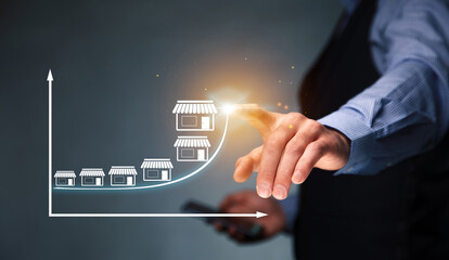 Man holding smartphone with a Franchise icons.