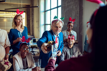 Diverse colleagues having office Christmas party team toasting with champagne