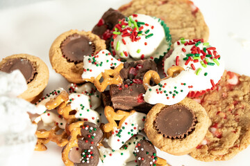 Assorted holiday desserts with cookies on white tissue paper
