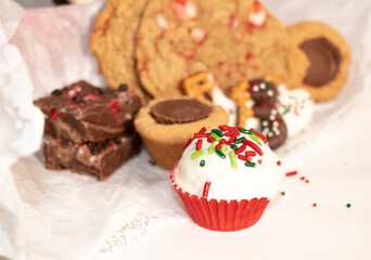 assorted holiday desserts with festive truffle on white tissue paper