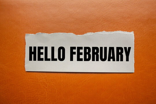 Hello february message written on ripped torn paper piece with brown background. Conceptual hello february symbol. Copy space.