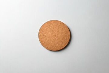 Simple round cork coaster with textured surface, placed on clean
