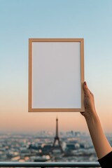 Hand holds empty frame against stunning cityscape with Eiffel To