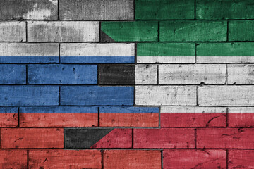 colourful painted big flag of russia and flag of kuwait on a massive old brick wall background. concept
