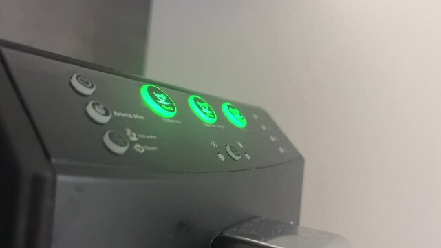 Blinking buttons on a sleek black coffee machine panel in modern kitchen setting