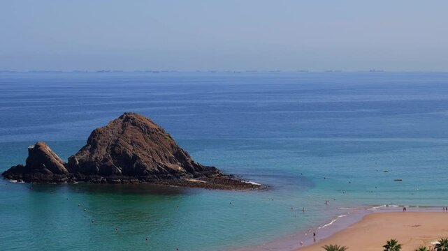 panorama of Snoopy Island in Fujairah, UAE. Aerial view of the beach with turquoise waters, a rocky island and a resort nearby
