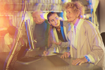 Grandparents and kids standing in escape room and using computer to solve riddles.