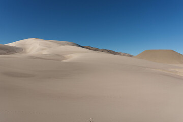 Peaceful dunes. Vast sand dunes stretching across the Campo de Piedra Pómez, with a brilliant blue sky above. Located in Catamarca, Argentina, this surreal landscape is marked by its striking contrast