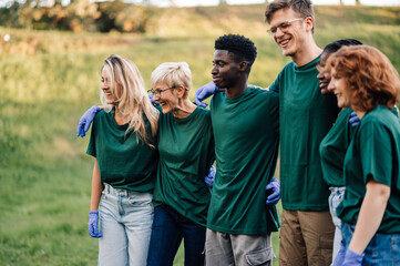 Group of volunteers wearing matching shirts is smiling and posing for a photo