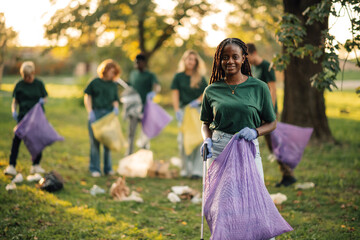 Group of people volunteers cleaning park picking up trash