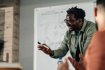 Smiling teacher explaining lesson to students in classroom