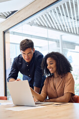 Business team two happy diverse young professional executives working together using laptop...