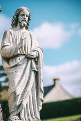 Obraz premium Stone statue of jesus christ holding a cross on church wall
