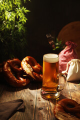 A mug with beer and traditional German bretzels in Bavarian rustic style