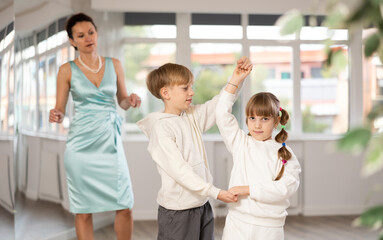 Passionate tween dancers, girl and boy practicing ballroom dancing in dance studio, gracefully...