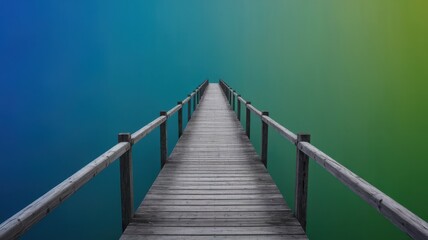 Obraz premium A tranquil wooden pier stretches over calm waters, blending into a gradient of blue and green hues, evoking a sense of peace and reflection.