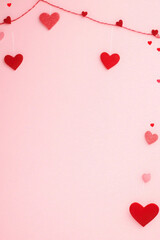 Valentine's Day background with red and pink heart-shaped decorations on a pink surface. Perfect for romantic, love-themed projects and celebrations 