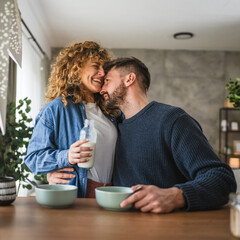 happy couple prepare oatmeal with milk for breakfast together at home