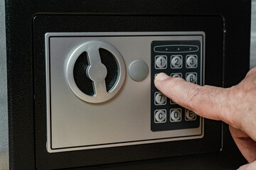 Man entering the opening code on the numeric keypad of the safe.