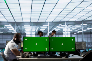 Green screen PC multi monitor setup in server hub workspace used by team of engineers to repair devices storing datasets. Chroma key computer used by workers for servicing rigs doing operations